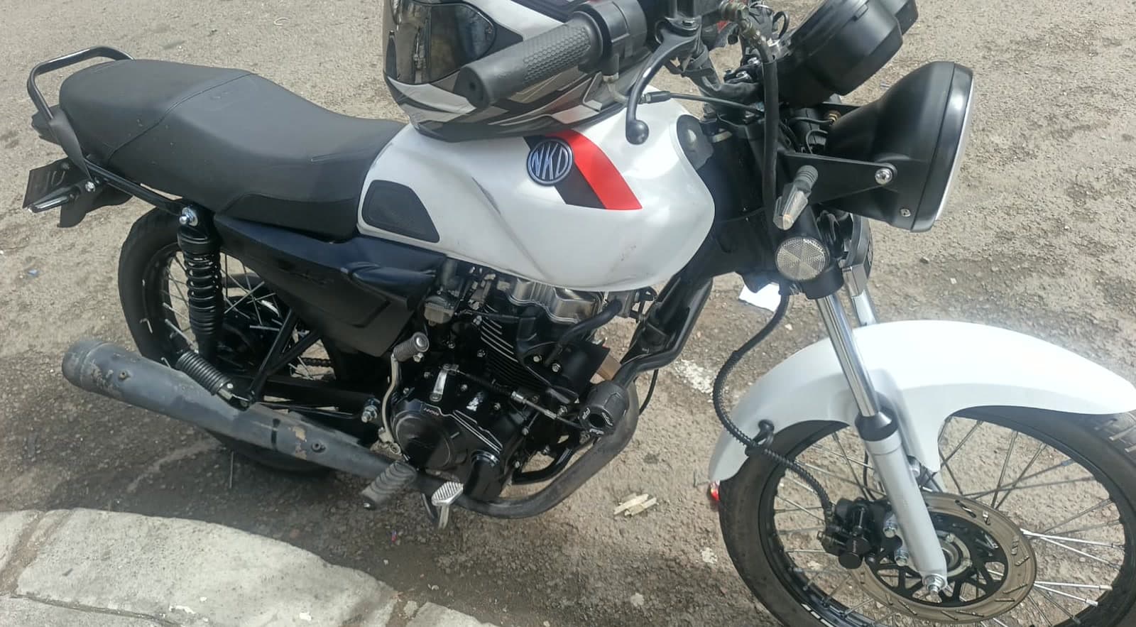 Motocicleta AKT NKD 125 blanca de la flota de Renmoto en Bogotá